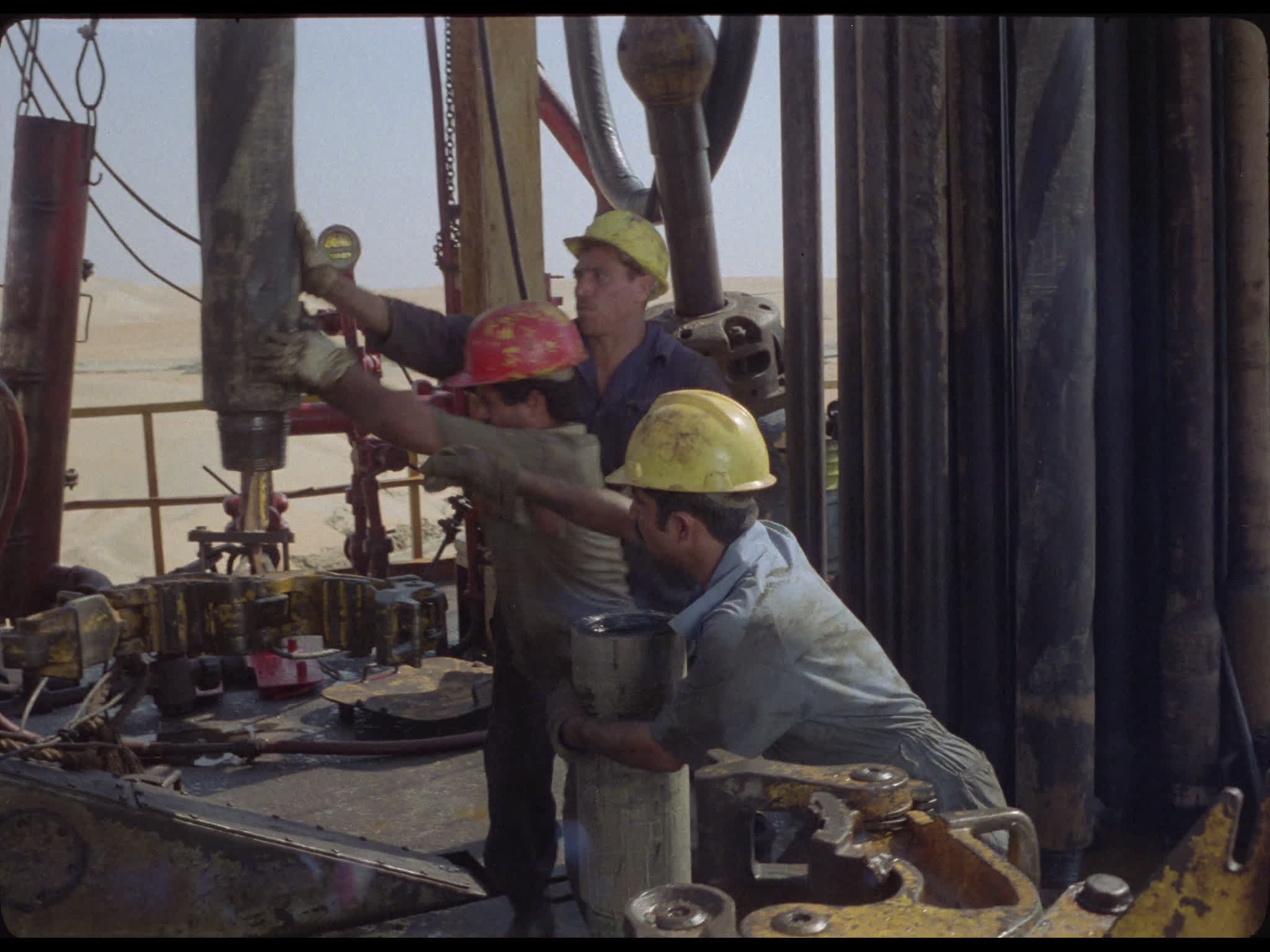 Team Tighten Drill Pipes at Well Head on Drilling Platform