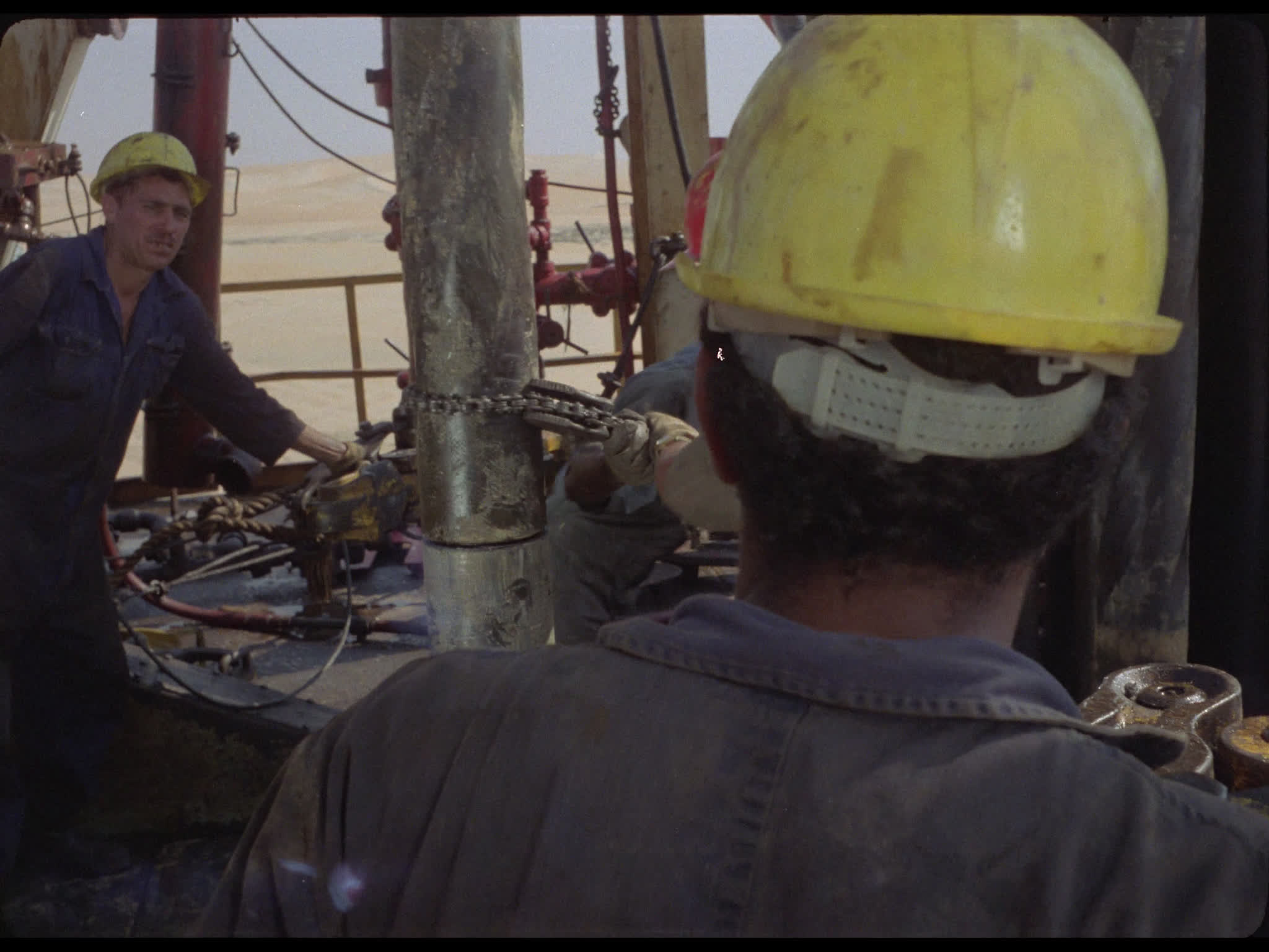 Team Tighten Drill Pipes at Well Head on Drilling Platform