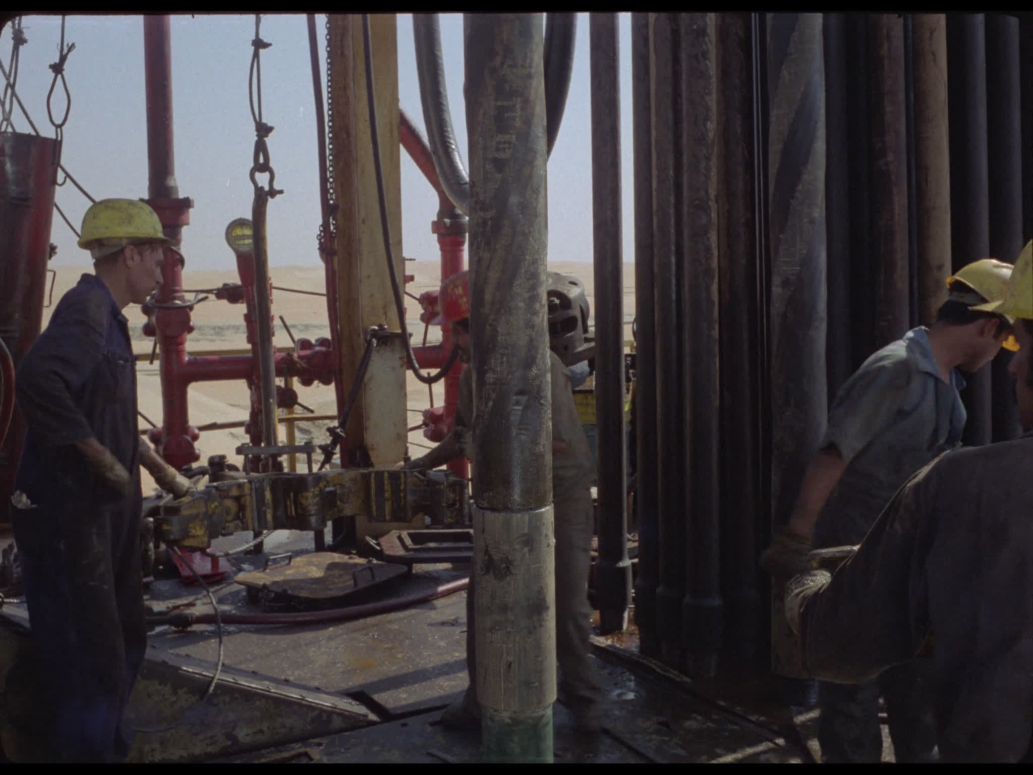 Team Tighten Drill Pipes at Well Head on Drilling Platform