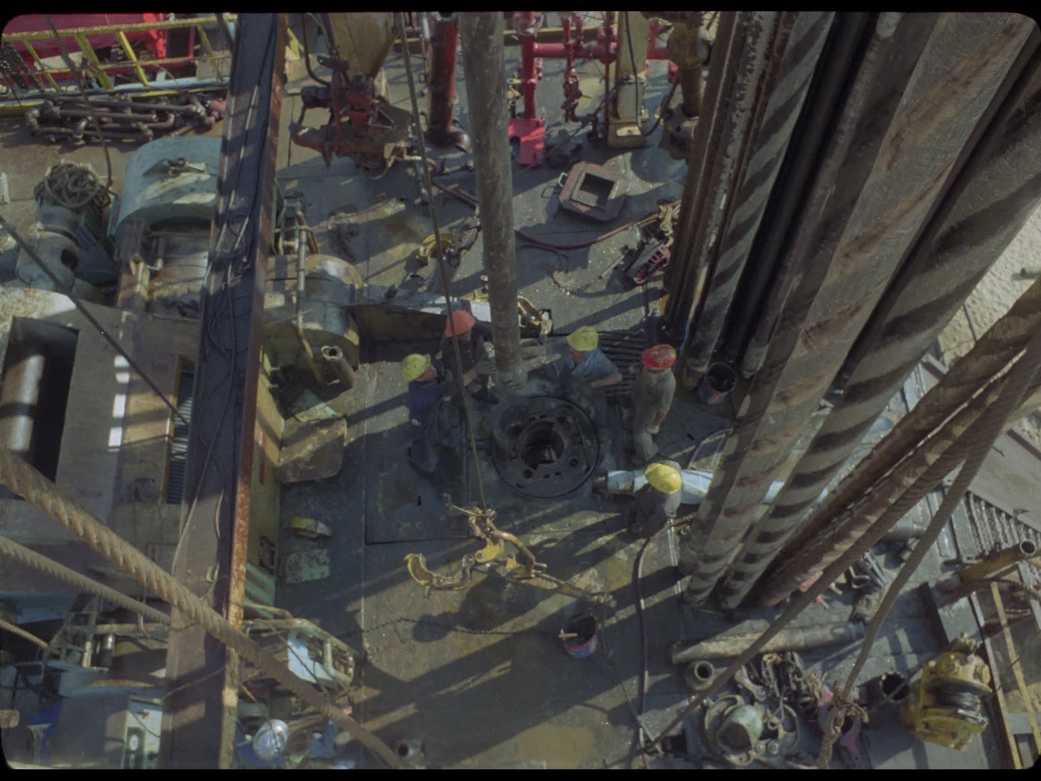 Drill Comes Down Towards Workers on Oil Derrick