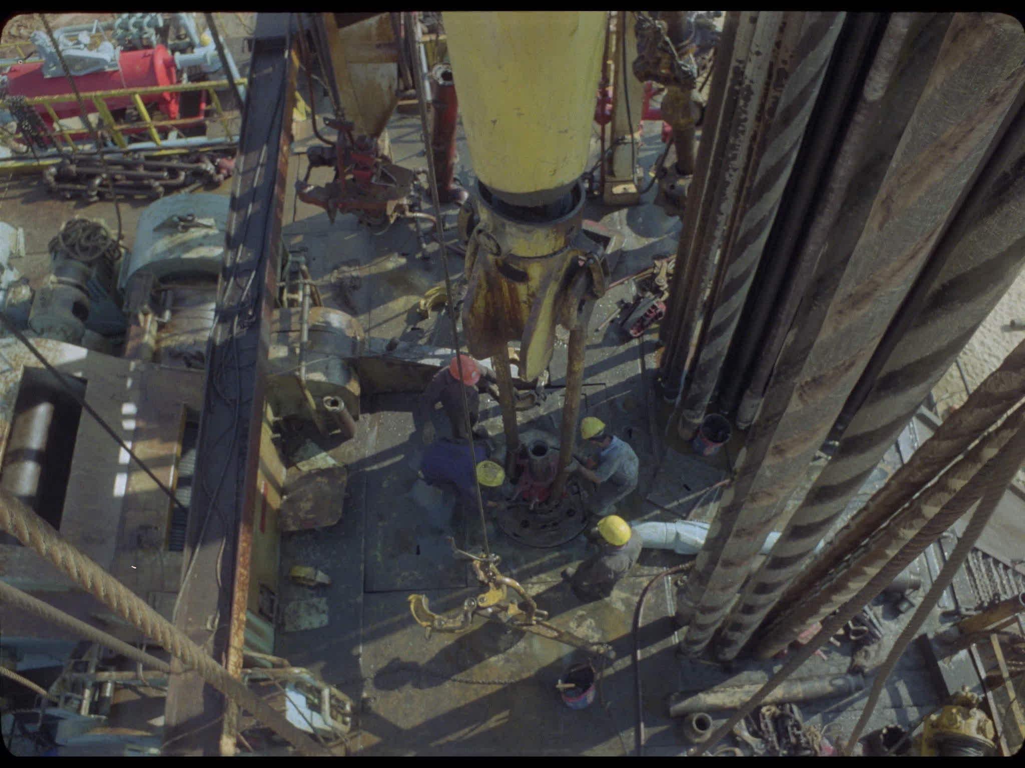 Drill Comes Down Towards Workers on Oil Derrick