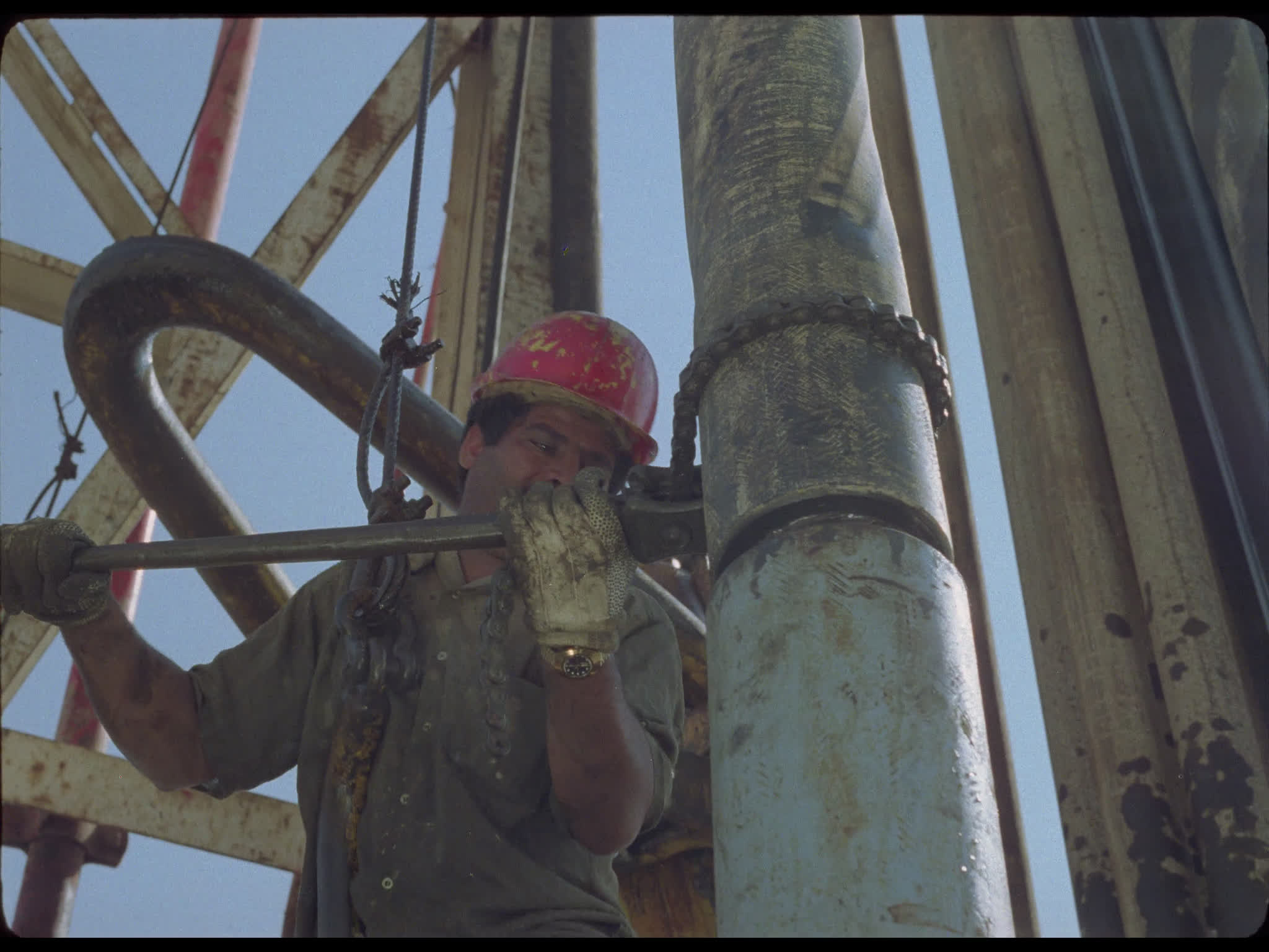Worker Tightens Drill Pipes at Well Head on Drilling Platform