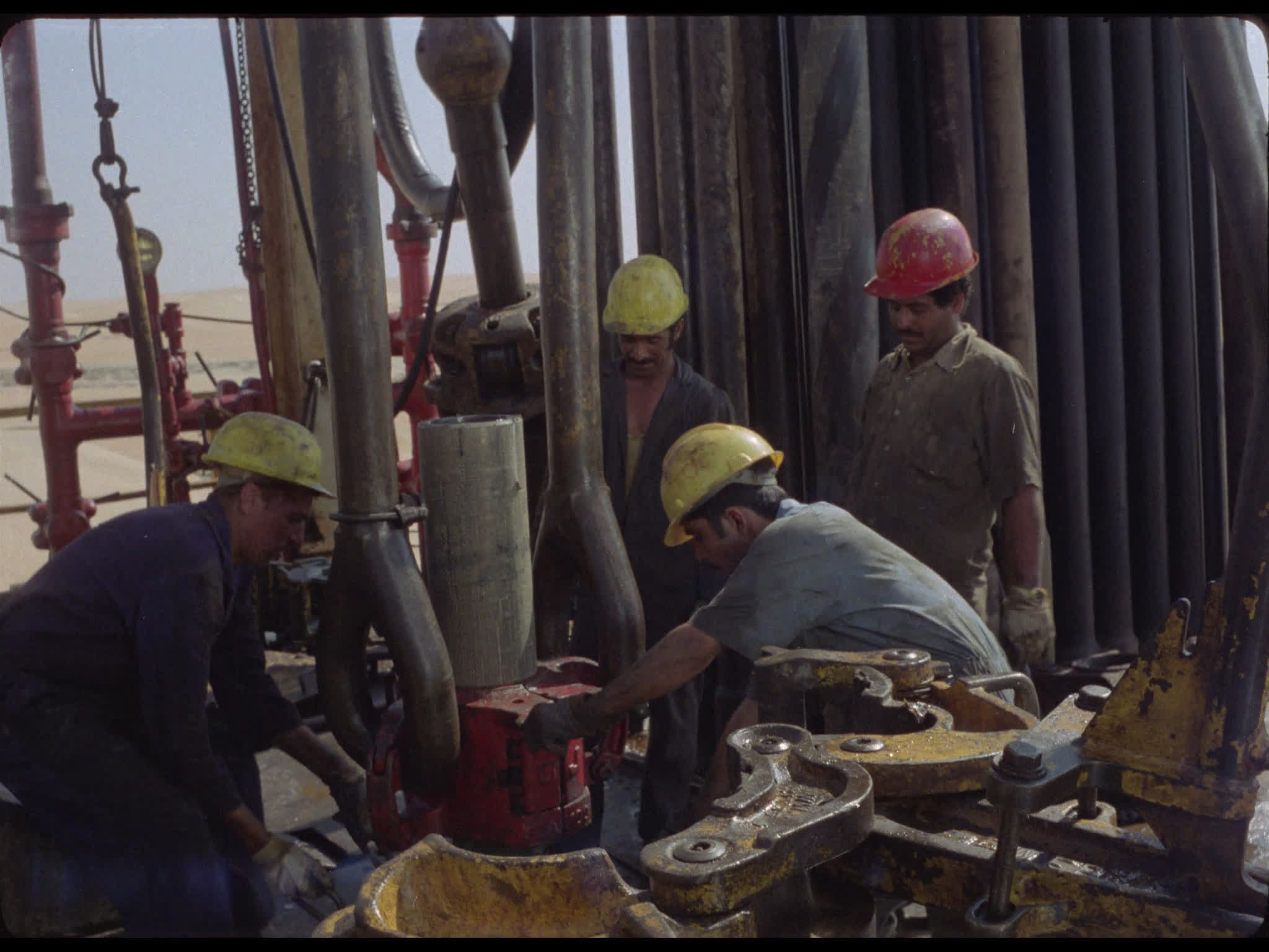 Team Tighten Drill Pipes at Well Head on Drilling Platform