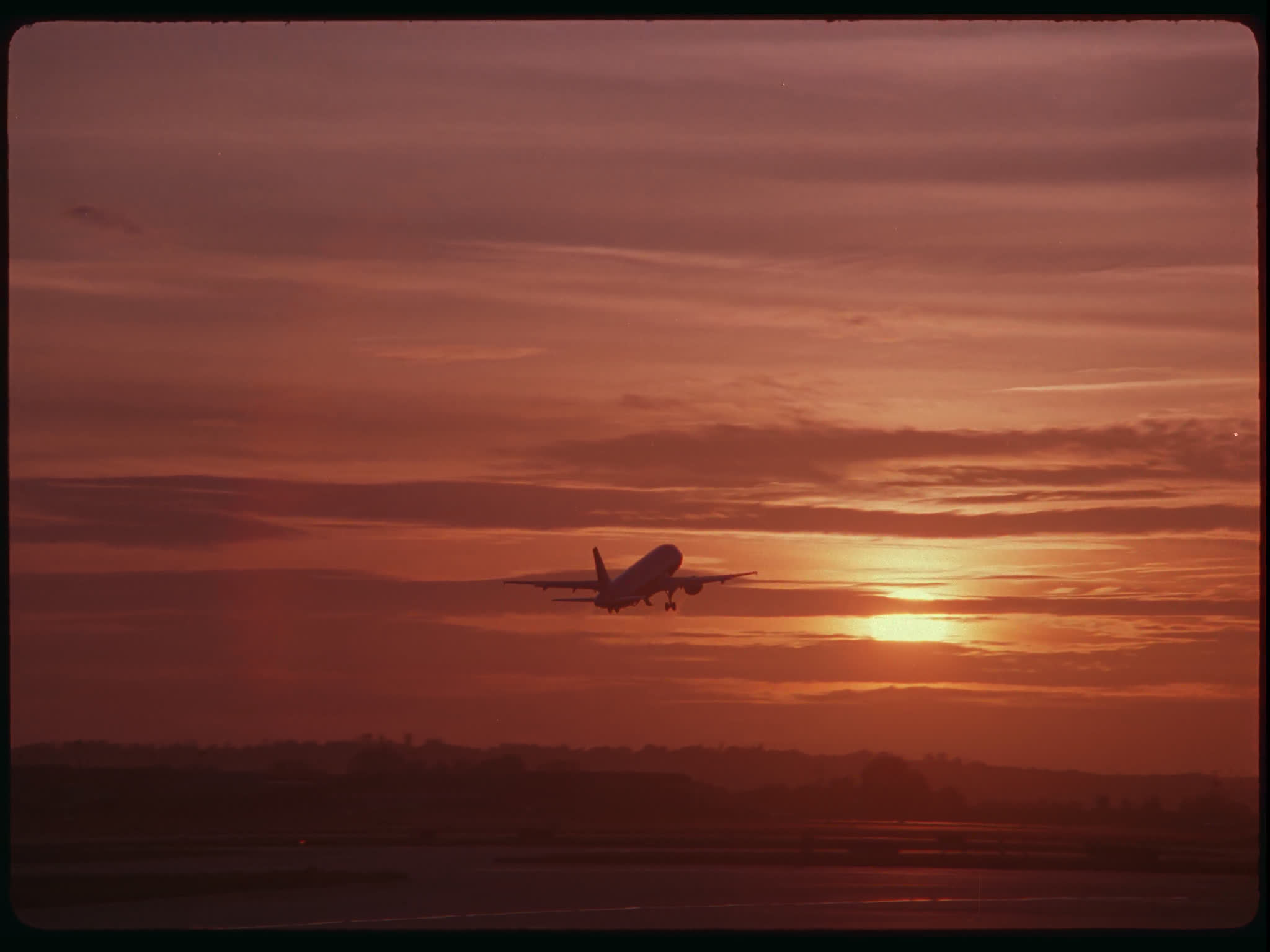 Plane Taking Off Into Sunset