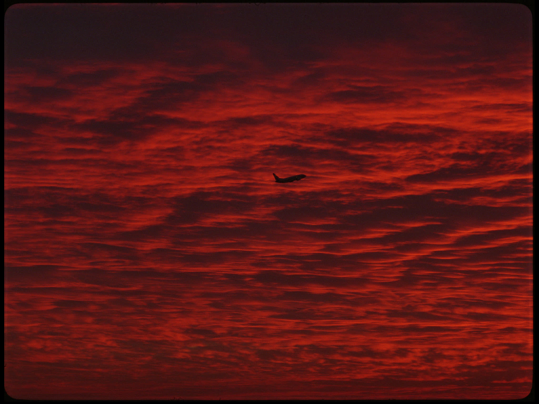 Plane Flying Against Red Sky