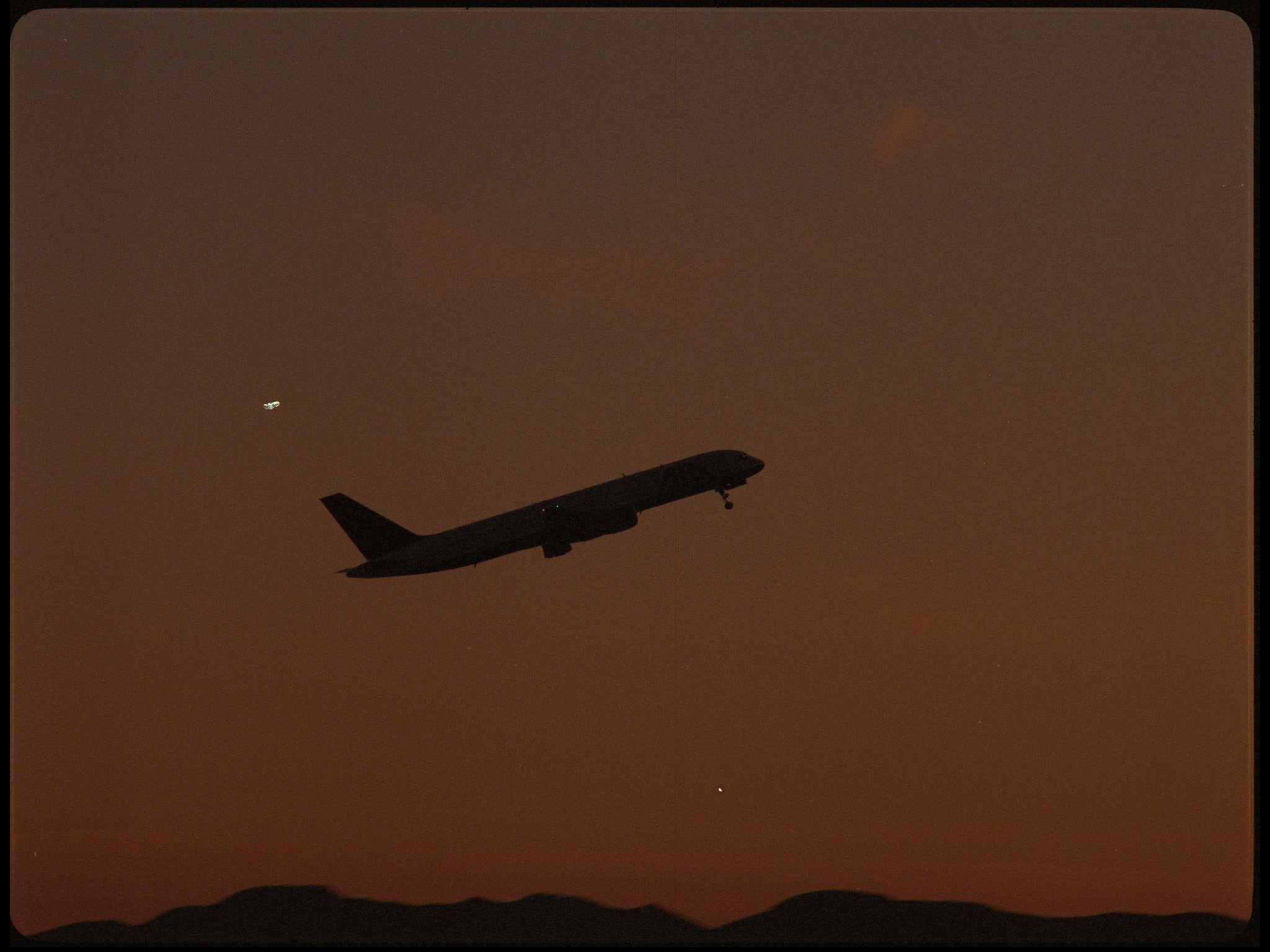 Plane Taking Off Into Sunset
